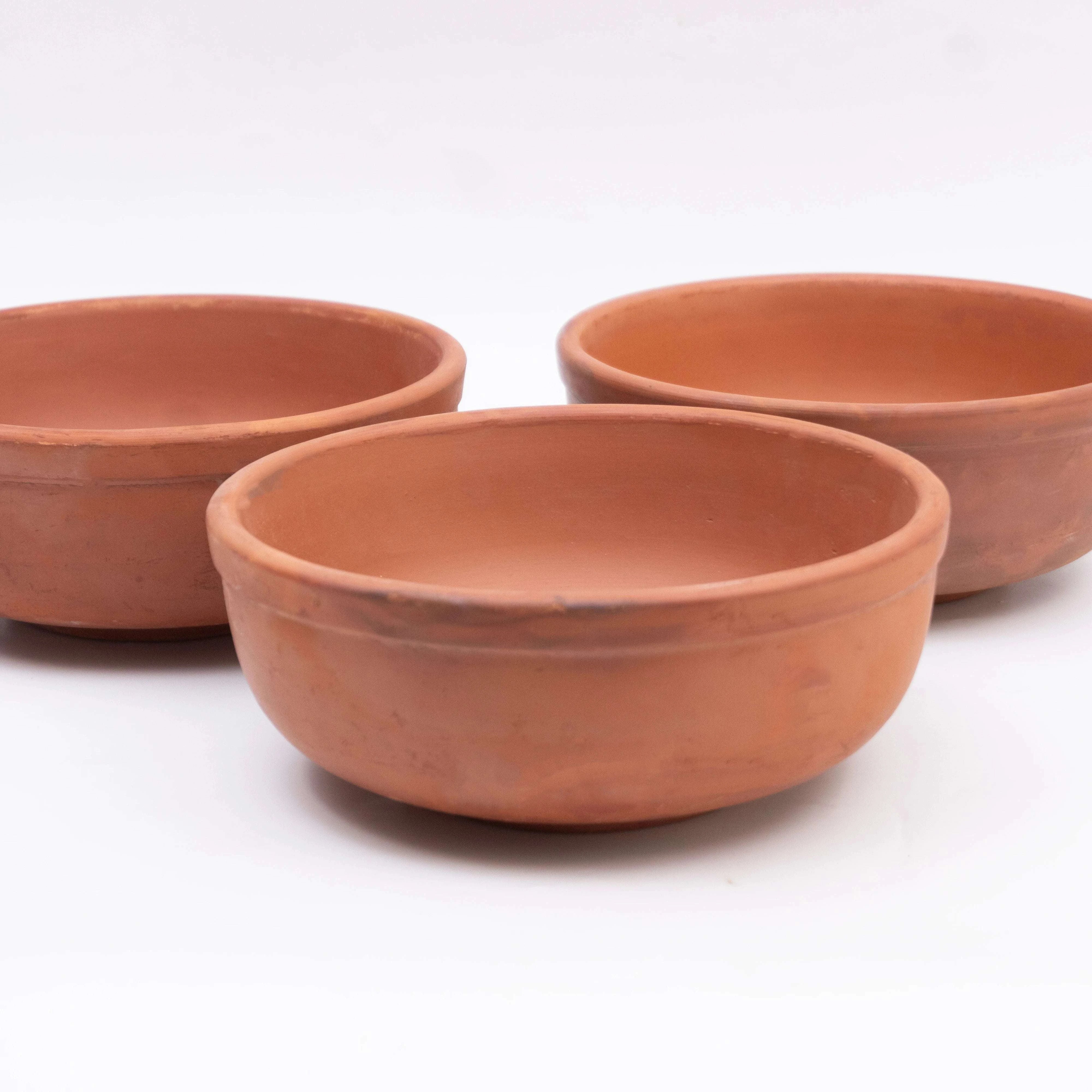 Three terracotta bowls on a white background