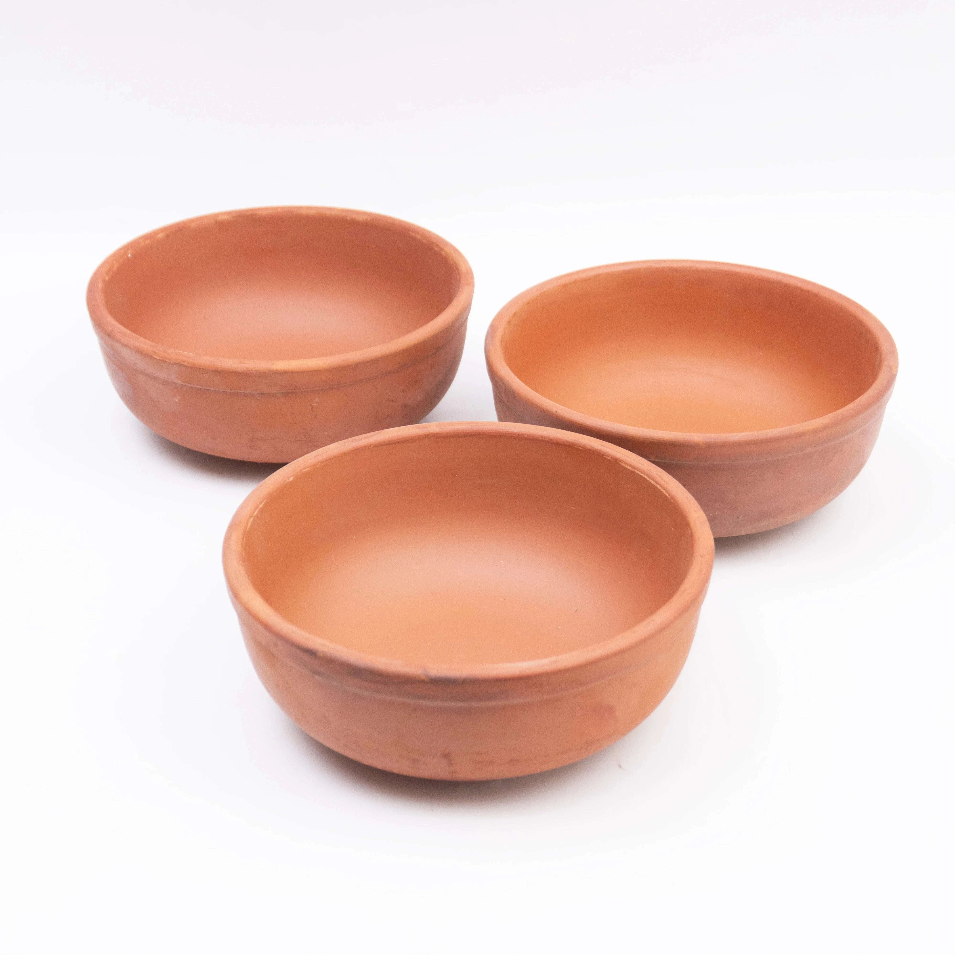 Three terracotta bowls on a white background