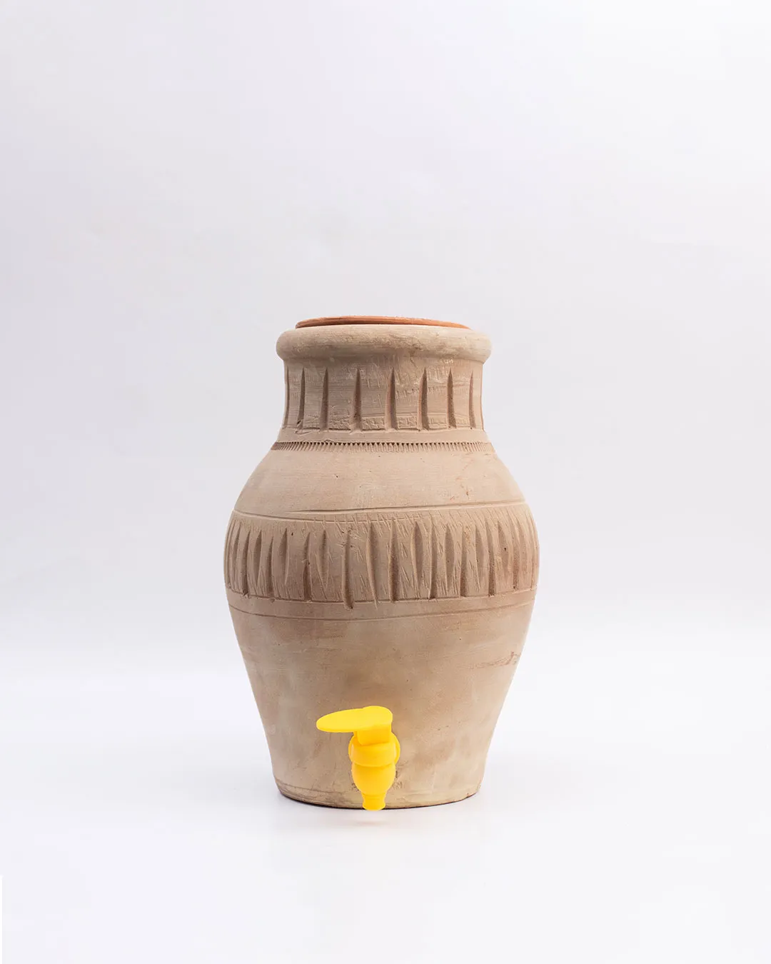 Eco-friendly Clay Cooler 5L with yellow tap and lid beside a white flower vase on table.