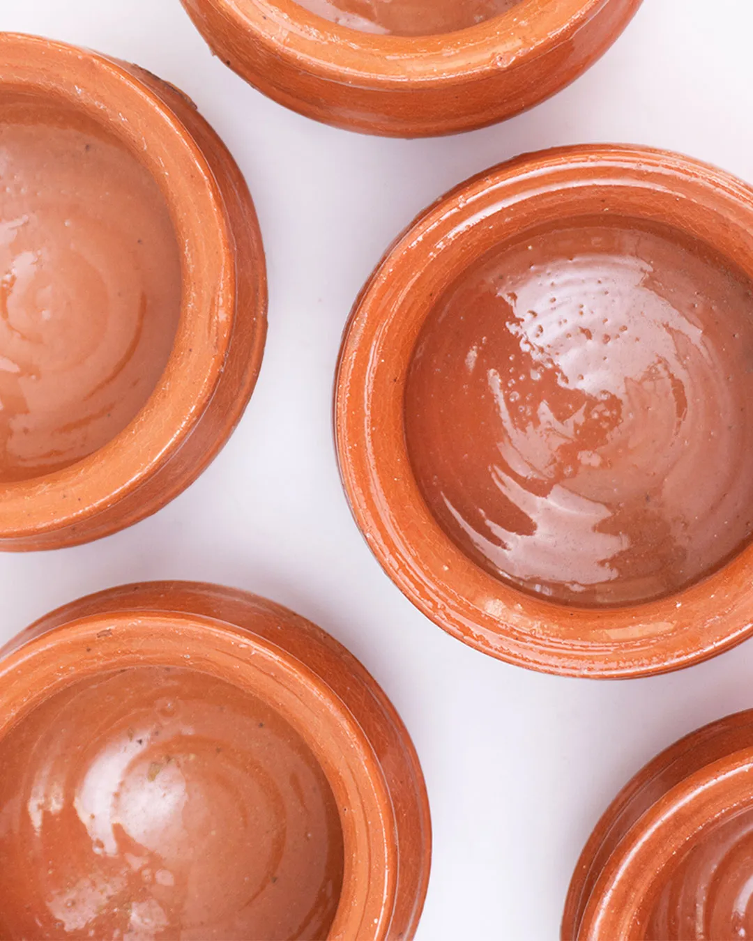 Set of six handcrafted clay mini handis with glossy finish, ideal for serving or décor.