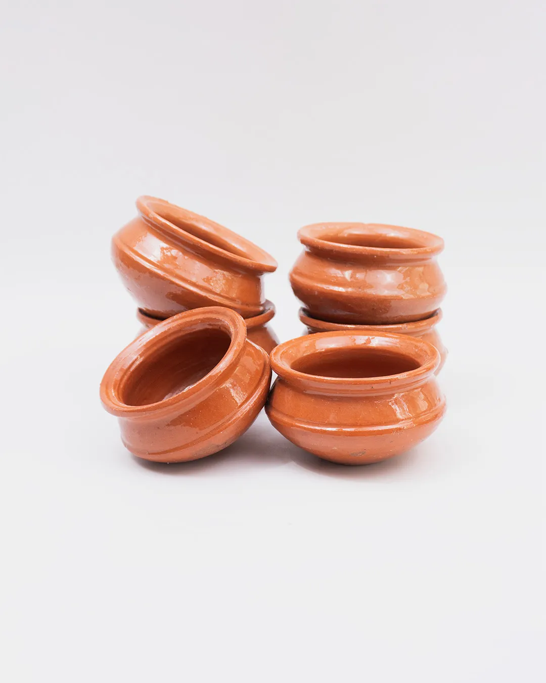 Set of six handcrafted clay mini handis with glossy finish, ideal for serving or décor.